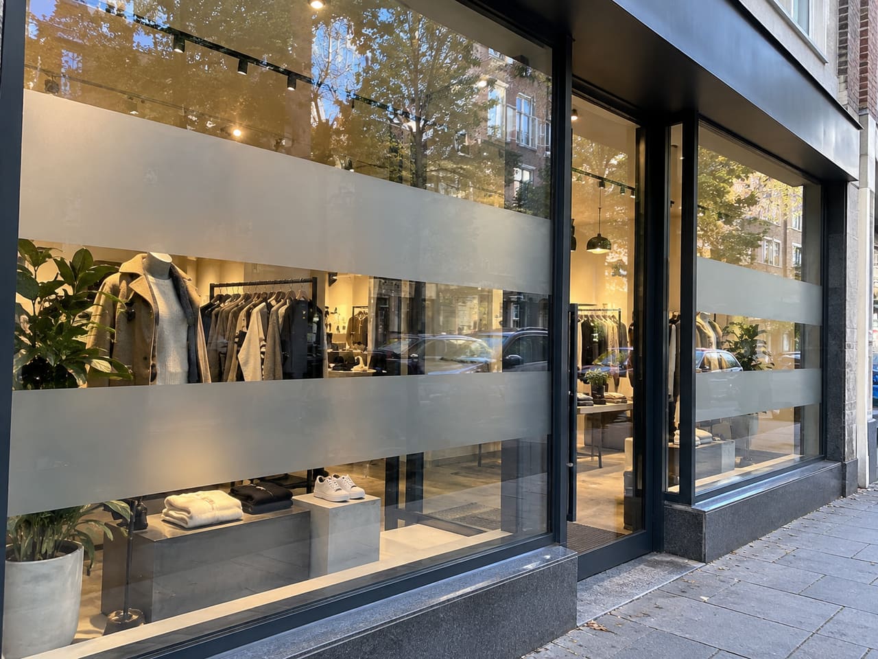 Winkeletalage met brede matte stroken en zicht op de winkel tussen de stroken.